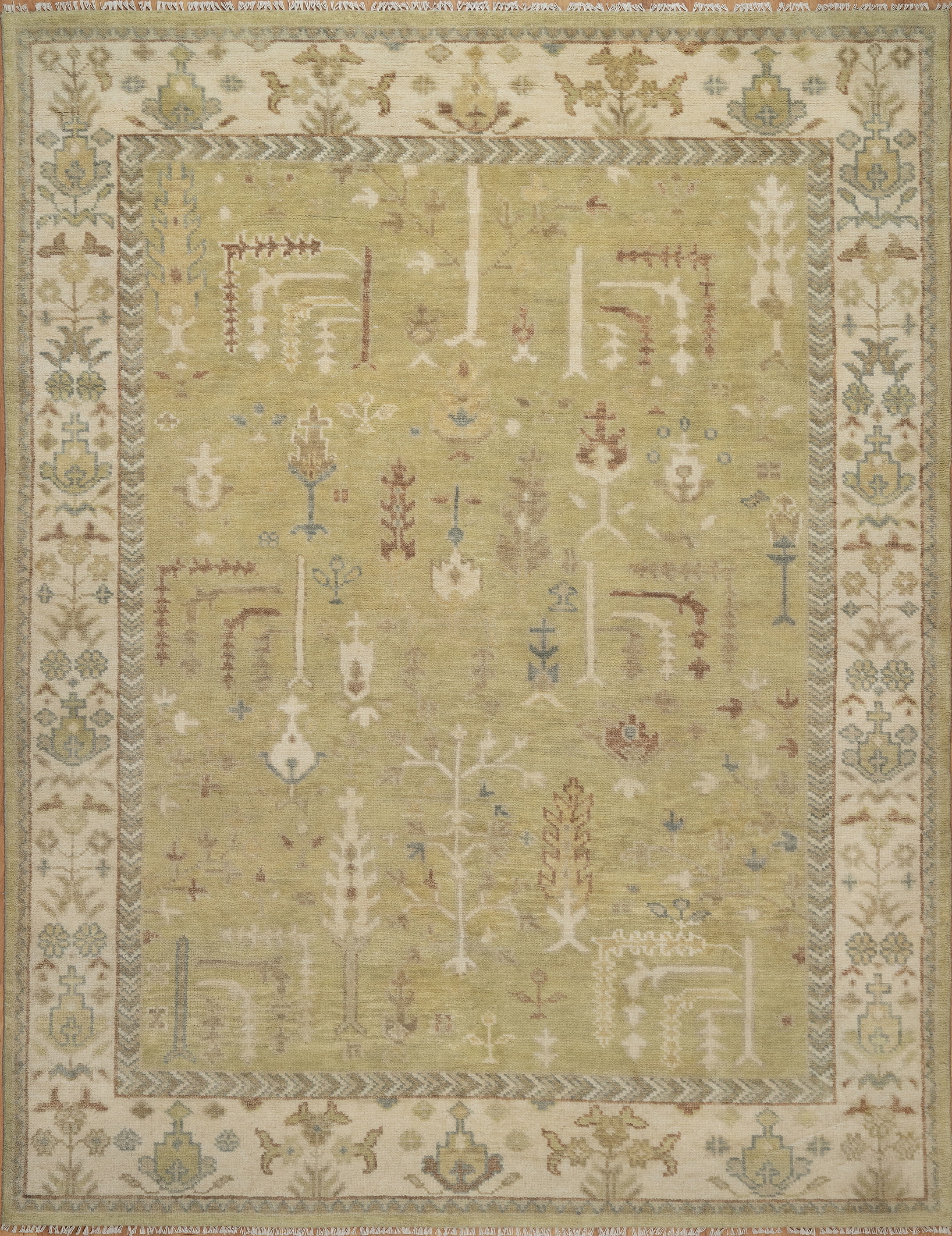 Hand-knotted wool Oushak rug with a sage-green field, ivory multi-band border, and scattered botanical palmette and tree motifs in soft rust, cream, and slate tones.