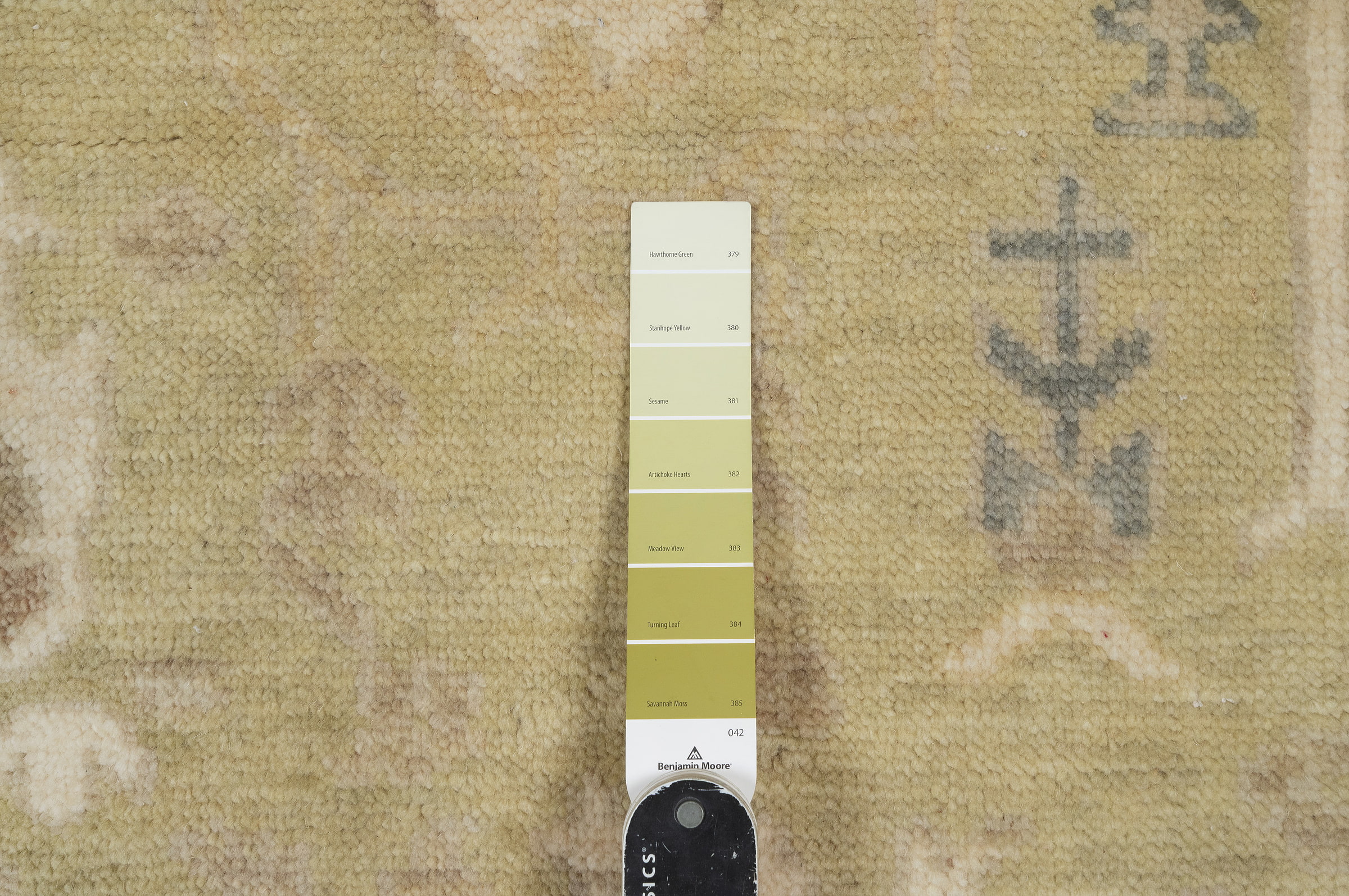 Hand-knotted wool Oushak rug with a sage-green field, ivory multi-band border, and scattered botanical palmette and tree motifs in soft rust, cream, and slate tones.