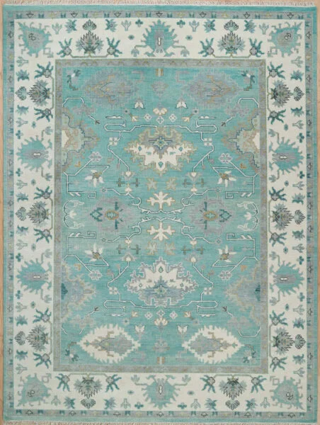 Hand-knotted wool Oushak rug with a light aqua field, wide ivory border, and tonal palmette, vine, and serrated-leaf motifs in sage and cream.