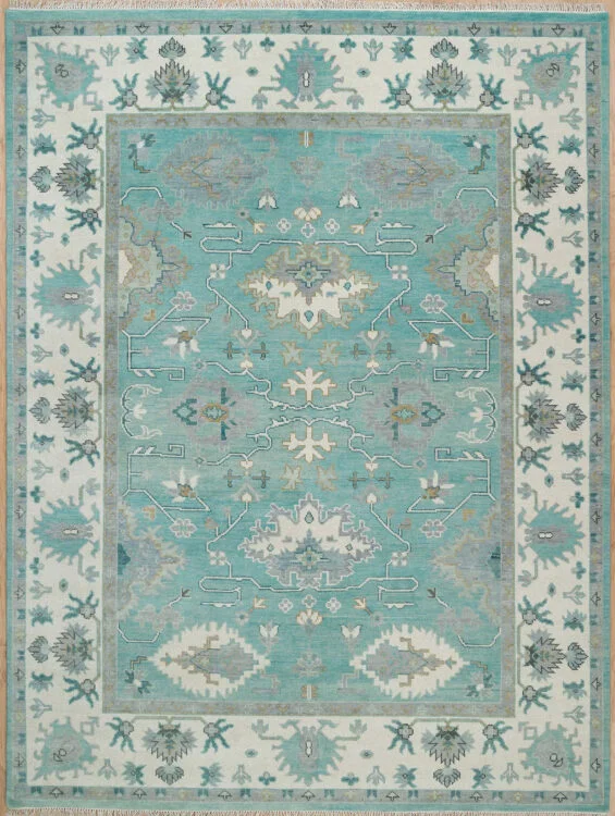 Hand-knotted wool Oushak rug with a light aqua field, wide ivory border, and tonal palmette, vine, and serrated-leaf motifs in sage and cream.