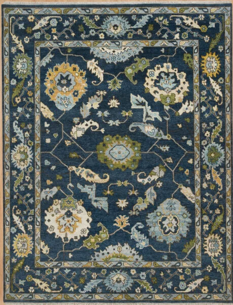 Hand-knotted wool Oushak rug with a deep navy field, wide navy border, and oversized palmette, rosette, vine, and serrated-leaf motifs in olive, gold, ivory, and teal.