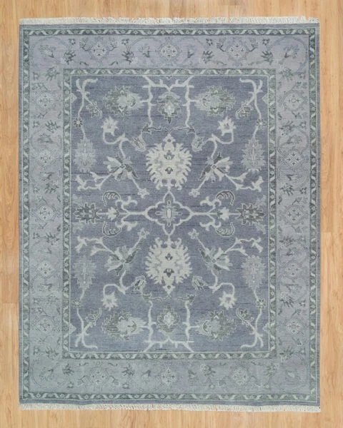 Hand-knotted wool oushak rug with a slate field, narrow slate border, and tonal palmette, vine, and serrated-leaf motifs in ivory and grey — near-monochrome with subtle figure-ground contrast.