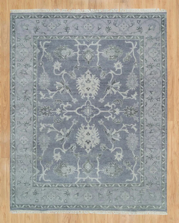 Hand-knotted wool oushak rug with a slate field, narrow slate border, and tonal palmette, vine, and serrated-leaf motifs in ivory and grey — near-monochrome with subtle figure-ground contrast.