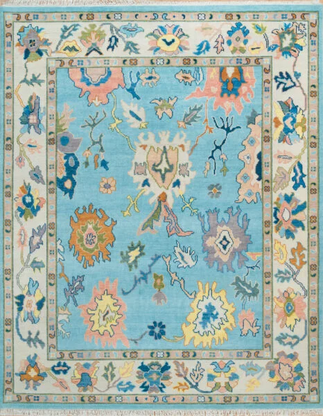 Hand-knotted wool oushak rug with a light aqua field, wide ivory border, and scattered palmettes and rosettes in blush, gold, navy, and sage with lively but balanced spacing.