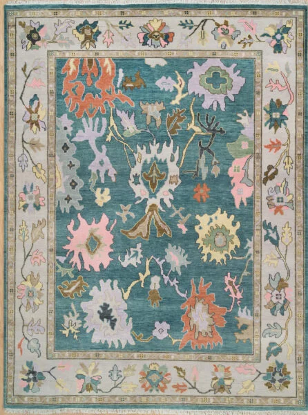 Hand-knotted wool oushak rug with a rich teal field, wide ivory border, and oversized palmettes and rosettes in vivid blush, coral, mauve, and ivory with high-drama contrast.