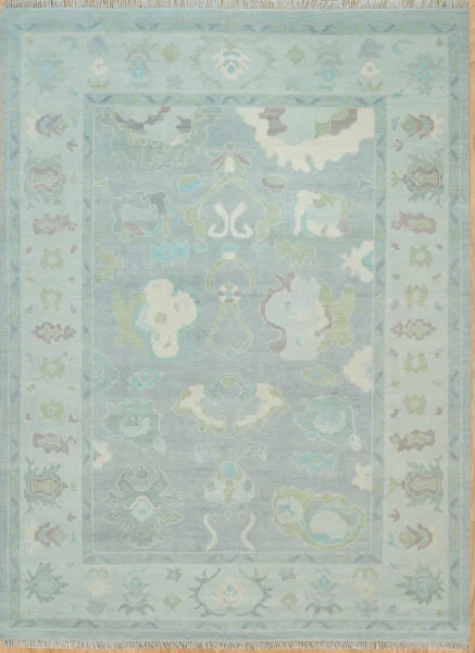 Hand-knotted wool oushak rug with a soft teal field, wide teal border, and tonal oversized palmettes, rosettes, and cloud-band motifs in sage and ivory.