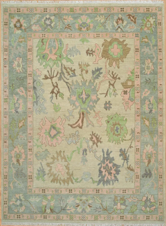 Hand-knotted wool oushak rug with a warm sand field, multi-band teal border, and balanced oversized palmettes and rosettes in blue, green, blush, and brown with comfortable spacing.