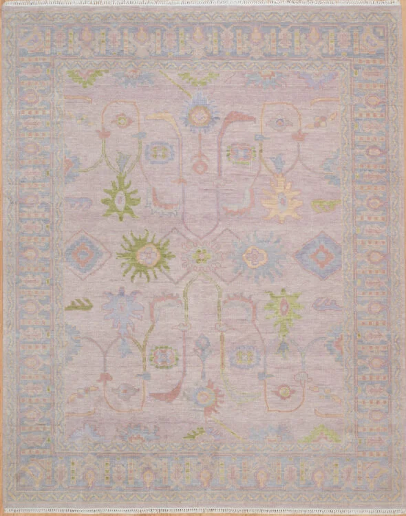 Hand-knotted wool oushak rug with a soft mauve-lavender field, wide grey-blue border, and airy pale green, blue, and blush palmettes, rosettes, and diamonds with generous open ground.