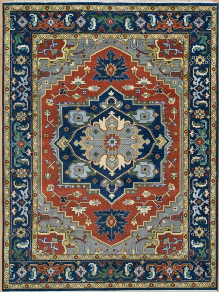 Hand-knotted wool medallion rug with a rust field featuring a large navy central medallion with palmettes in gold and grey, framed by a wide navy vine border.