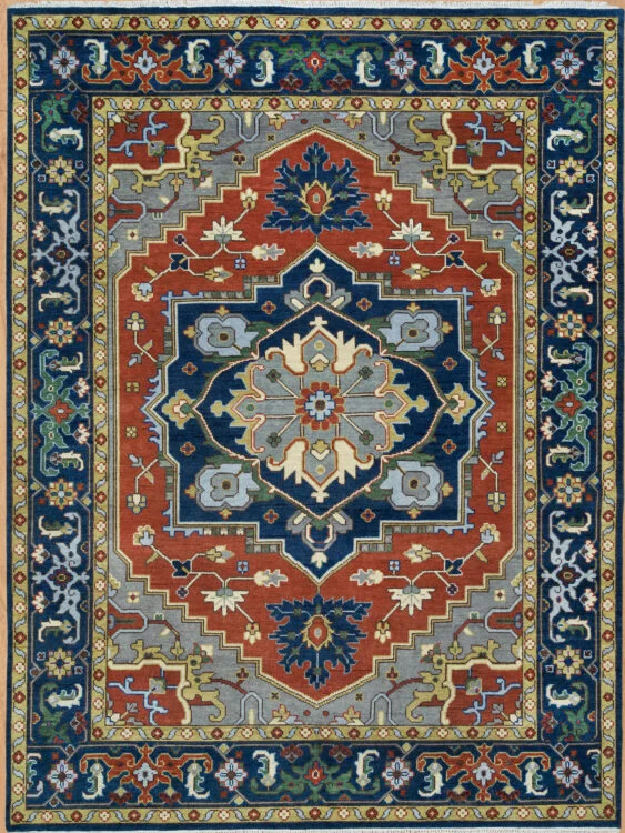 Hand-knotted wool medallion rug with a rust field featuring a large navy central medallion with palmettes in gold and grey, framed by a wide navy vine border.