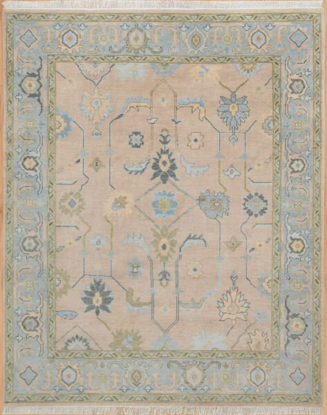 Hand-knotted wool Oushak rug with a sand field featuring palmettes and vine scrolls in dusty blue and olive, framed by a wide muted blue floral border.