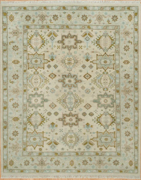 Hand-knotted wool Oushak rug with a beige field featuring palmettes and rosettes in olive and muted blue, framed by a wide pale blue border with geometric accents.