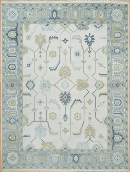Hand-knotted wool Oushak rug with ivory field, blue-grey border, and all-over floral palmettes in blue and gold.