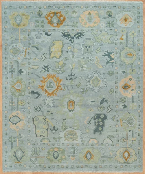 Hand-knotted wool Oushak rug with sage field and scattered floral palmettes in olive, gold, peach, and navy tones.
