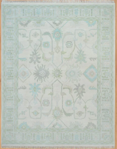 Hand-knotted wool Oushak rug with very light ivory field and muted sage, blue, and grey floral palmettes.
