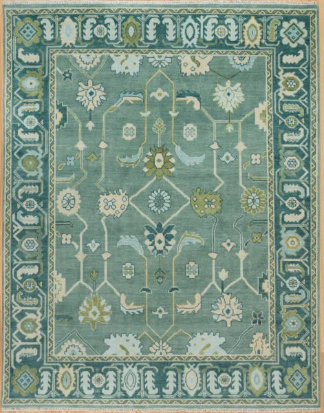 Hand-knotted modern Oushak wool rug with a sage green field, teal and ivory floral motifs with gold accents, and a deeper teal border.