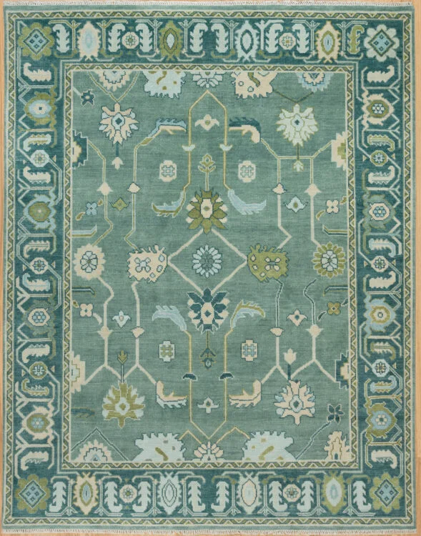 Hand-knotted modern Oushak wool rug with a sage green field, teal and ivory floral motifs with gold accents, and a deeper teal border.