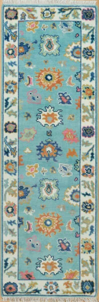 Hand-knotted modern Oushak wool runner with a bright aqua field, bold coral, navy and gold floral medallions, and ivory side borders.