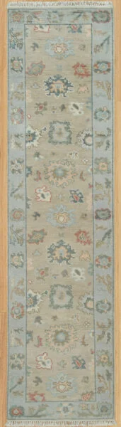 Hand-knotted modern Oushak wool runner with a warm beige field, muted blue-grey and rust palmettes, and a narrow blue border.