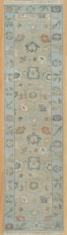 Hand-knotted modern Oushak wool runner with a warm beige field, muted blue-grey and rust palmettes, and a narrow blue border.