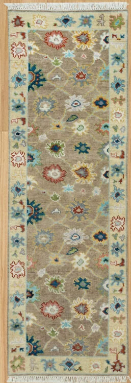 Hand-knotted modern Oushak wool runner with a warm taupe field, diamond lattice pattern holding blue, rust and teal rosettes, and a narrow ivory border.