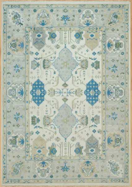 Hand-knotted modern Oushak wool rug with an ivory field, spaced soft blue palmettes, and a wide grey border with blue floral accents.