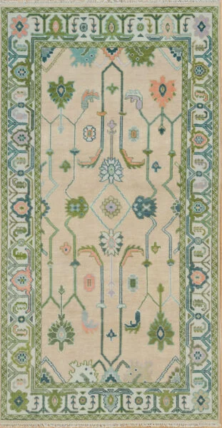 Hand-knotted modern Oushak wool rug with a warm beige field, green and sage palmettes with coral accents, and a wide sage geometric-floral border.