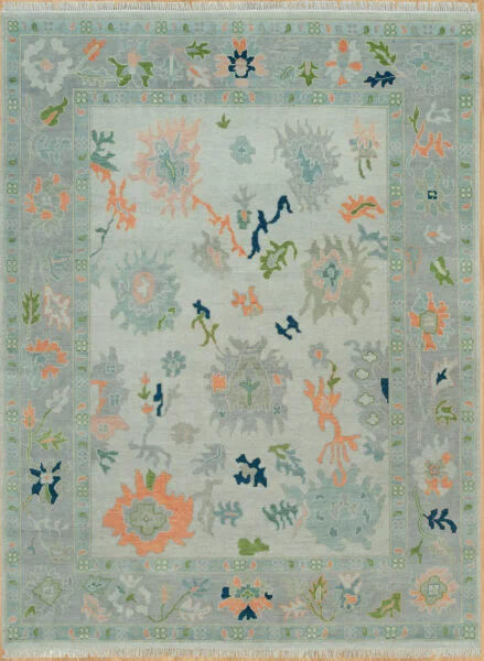 Hand-knotted modern Oushak wool rug with a soft sage field, muted coral and grey palmettes with navy accents, and a grey-blue floral border.