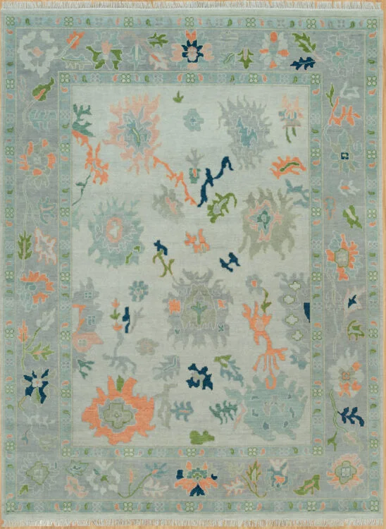 Hand-knotted modern Oushak wool rug with a soft sage field, muted coral and grey palmettes with navy accents, and a grey-blue floral border.