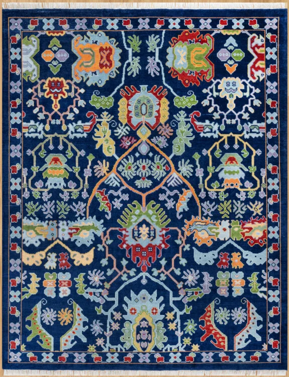Hand-knotted wool oushak rug with a deep navy field, wide navy-red border, and dense medium-scale palmettes, rosettes, and angular vines in red, green, gold, blue, and orange.