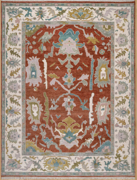 Hand-knotted wool oushak rug (9x12) with a rich rust field, wide ivory border, and balanced large-scale palmettes and rosettes in ivory, blue, olive, and mauve.