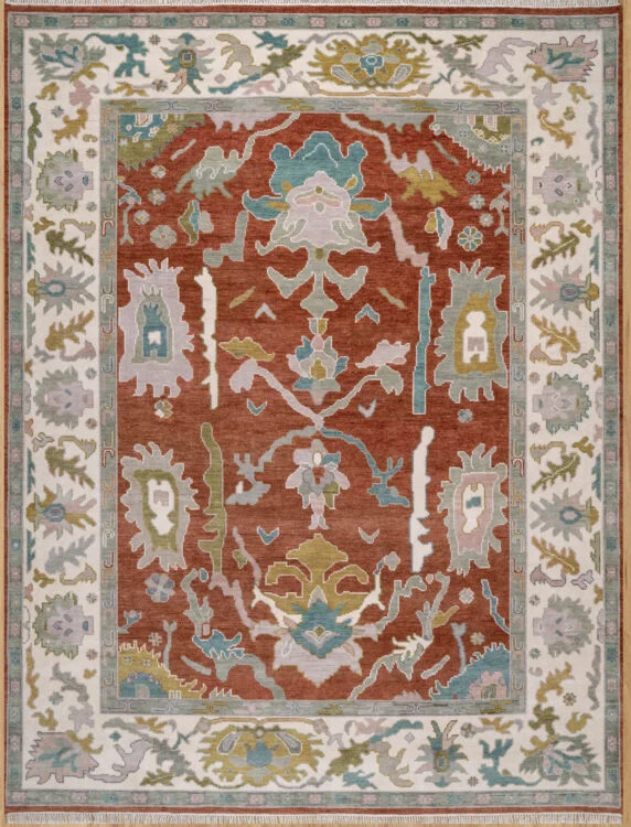 Hand-knotted wool oushak rug (9x12) with a rich rust field, wide ivory border, and balanced large-scale palmettes and rosettes in ivory, blue, olive, and mauve.