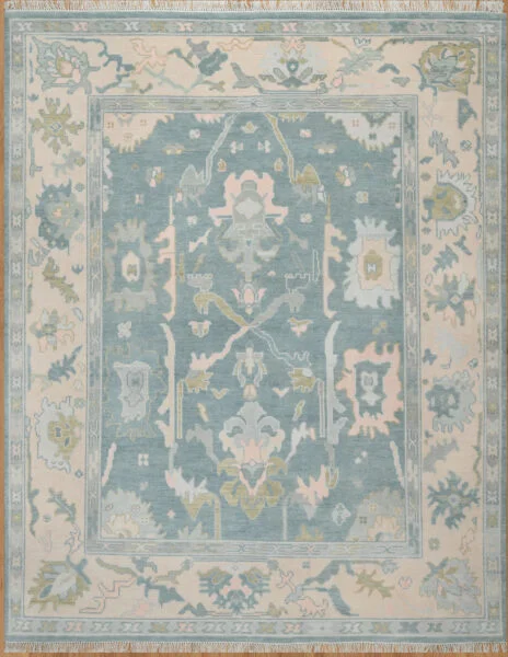 Hand-knotted wool oushak rug (8x10) with a mid-blue field, wide ivory border, and balanced large-scale palmettes and rosettes in ivory, sage, olive, and blush.