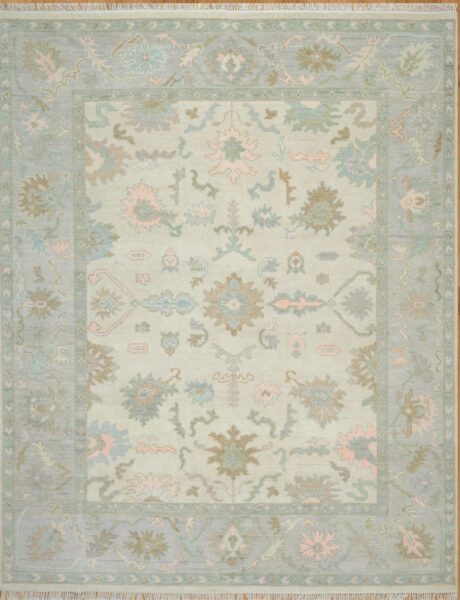 Hand-knotted wool oushak rug (8x10) with a very light ivory field, wide blue border, and open large-scale palmettes and rosettes in faint blue, olive, blush, and taupe.